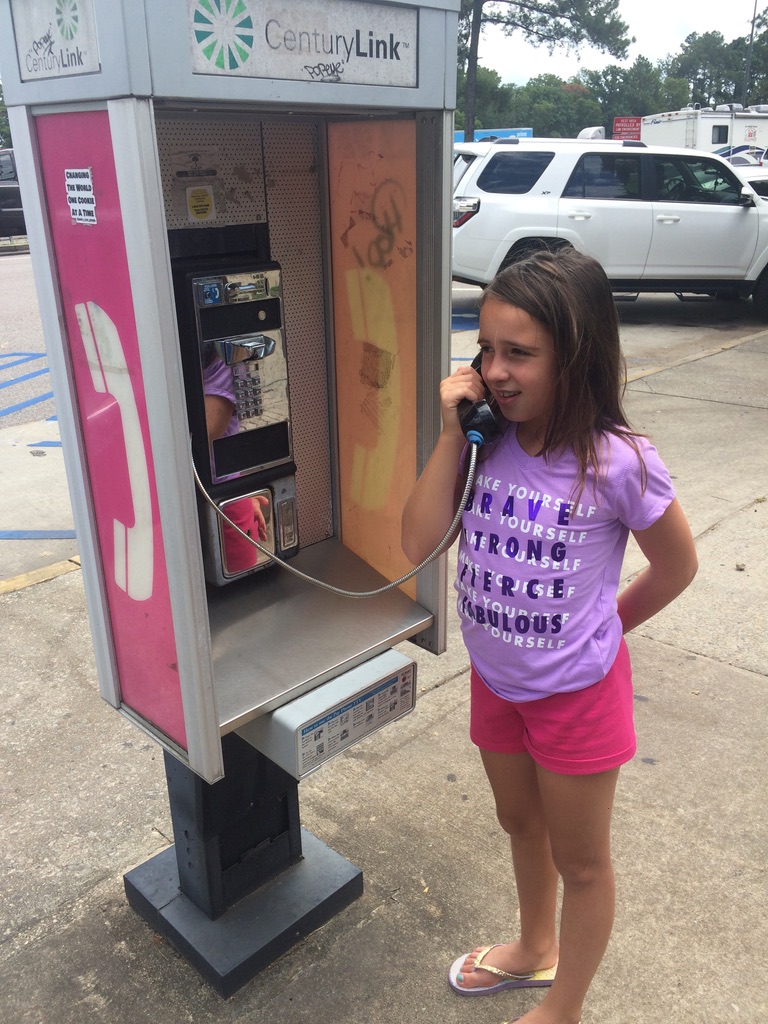 Kaylei interacting with a "pay phone" from last century.