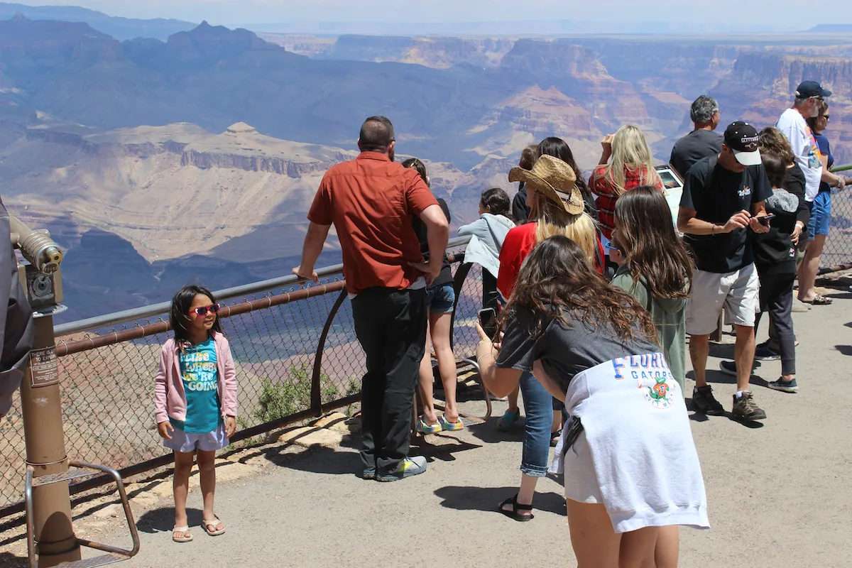 Oldest sister taking picture of the youngest sister while middle sister looks on.