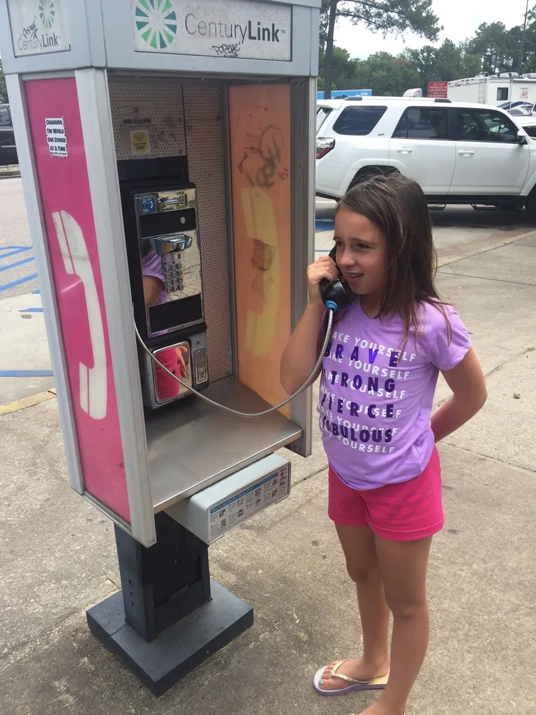 Kaylei interacting with a "pay phone" from last century.